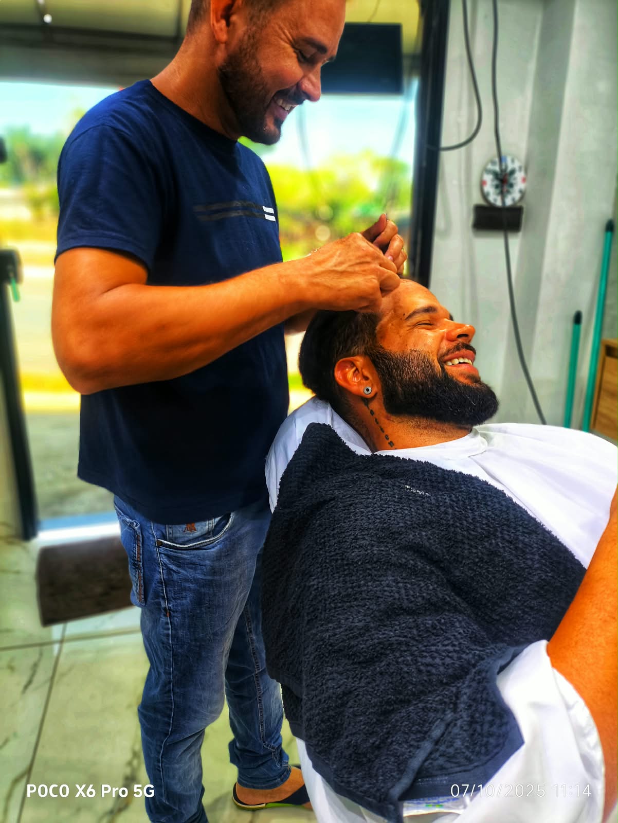 Barbeiro cuidando do cabelo de um cliente na Pai & Filho Barbearia